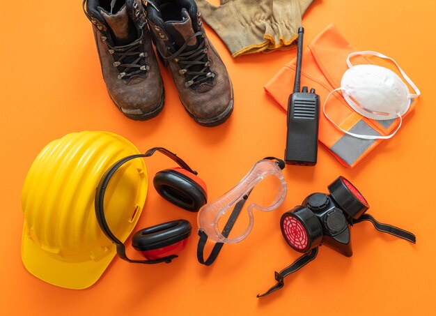 Foto werkkleding veiligheidsuitrusting oranje kleur achtergrond persoonlijke beschermingsmiddelen