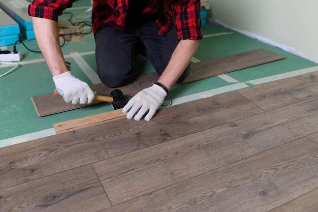 Werkman installeert laminaatreparatie van het appartement met laminaatvloeren van hoge kwaliteit k-beeldmateriaal