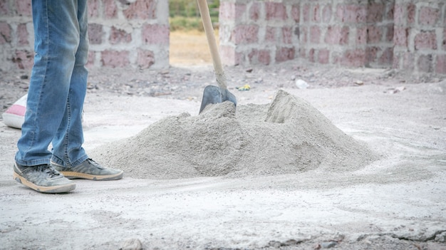 Werknemer bereidt beton met schop voor op de bouwplaats.