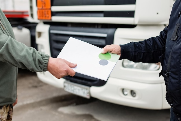 Foto werknemer controleert document voor de vorkheftruck bij import-exportbedrijf in magazijnen