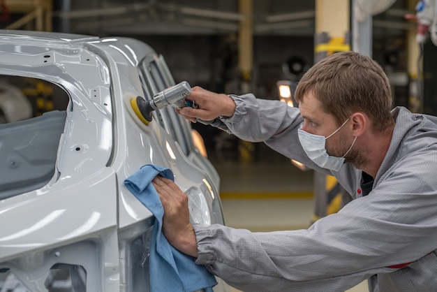 Werknemer die de carrosserie schildert