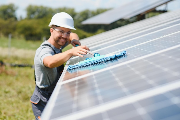 Werknemer die zonnepanelen schoonmaakt na installatie buitenshuis