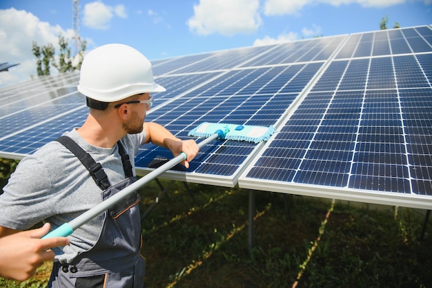 Werknemer die zonnepanelen schoonmaakt na installatie buitenshuis