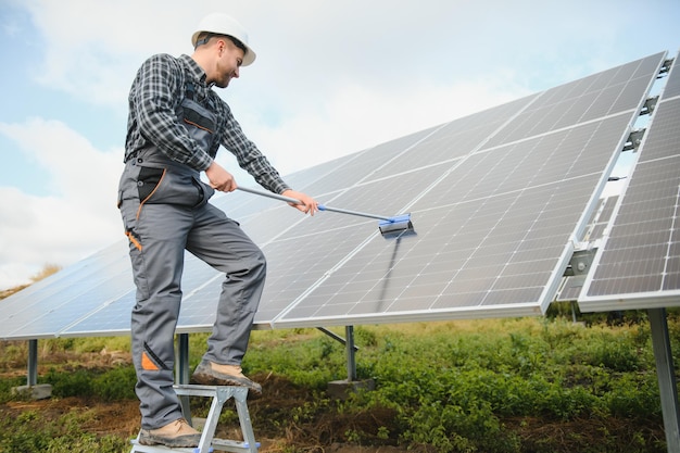 Werknemer die zonnepanelen schoonmaakt na installatie buitenshuis