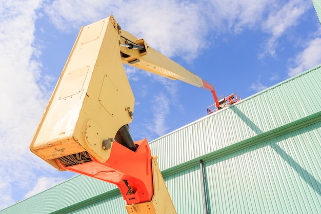 Werknemer man op een schaar Hydraulische heftafel Platform naar een fabrieksdak