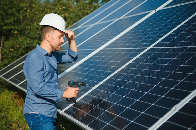 Werknemer technicus die zware fotovoltaïsche zonnepanelen verbindt met een hoog stalen platform Exterieur zonnestelsel installatie alternatief concept voor de opwekking van groene energie