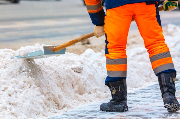 Werknemer van de gemeentedienst veegt sneeuw van de weg in de winter, maakt stadsstraten en wegen schoon tijdens sneeuwstorm. Moskou, Rusland.