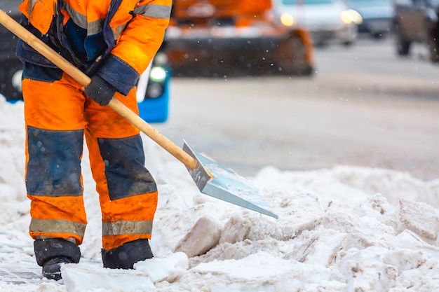 Werknemer van de gemeentedienst veegt sneeuw van de weg in de winter, maakt stadsstraten en wegen schoon tijdens sneeuwstorm. Moskou, Rusland.