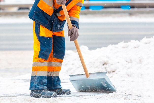 Werknemer van de gemeentedienst veegt sneeuw van de weg in de winter, maakt stadsstraten en wegen schoon tijdens sneeuwstorm. Moskou, Rusland.