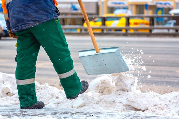 Werknemer van de gemeentedienst veegt sneeuw van de weg in de winter, maakt stadsstraten en wegen schoon tijdens sneeuwstorm. Moskou, Rusland.