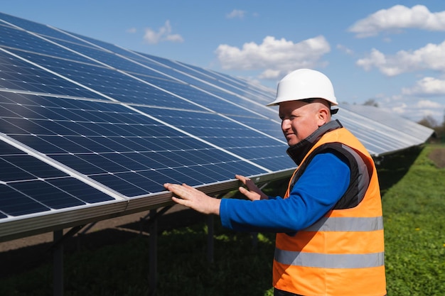 Werknemer van een zonnecentrale inspecteert fotovoltaïsche panelen op schade