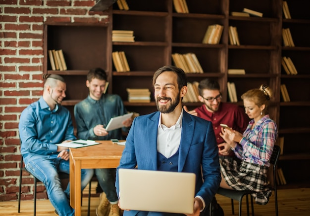 werknemer van het bedrijf met een laptop en een zakelijk team dat de huidige problemen van het bedrijf bespreekt