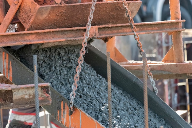 Werknemers gieten beton in de fundering op een bouwplaats Betonneren van de fundering tijdens de constructie van het gebouw Betonwerken