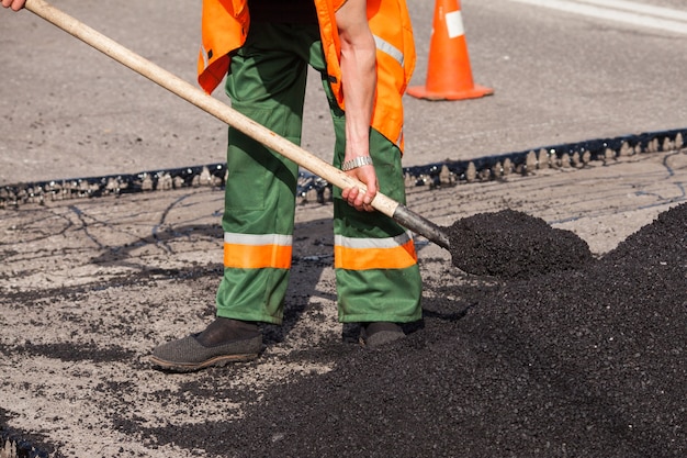 Werknemers op asfaltering bestratingsafwerkmachines machine tijdens straatreparatiewerkzaamheden weg