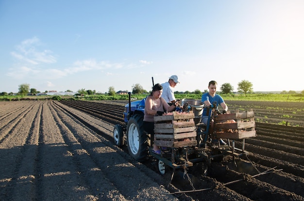 Werknemers poten aardappelen op het veld Automatisering van het proces van het planten van aardappelzaden Landbouwtechnologieën Agro-industrie en agribusiness Nieuwe technologische oplossingen om het werk te vereenvoudigen