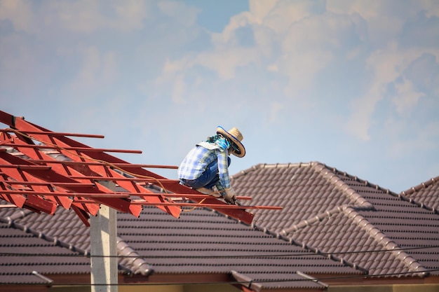 Werknemers van bouwlassers die stalen framestructuur van het huisdak installeren