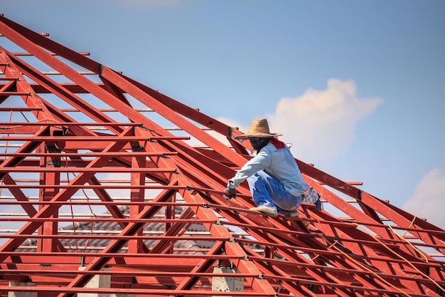 Foto werknemers van bouwlassers die stalen framestructuur van het huisdak installeren