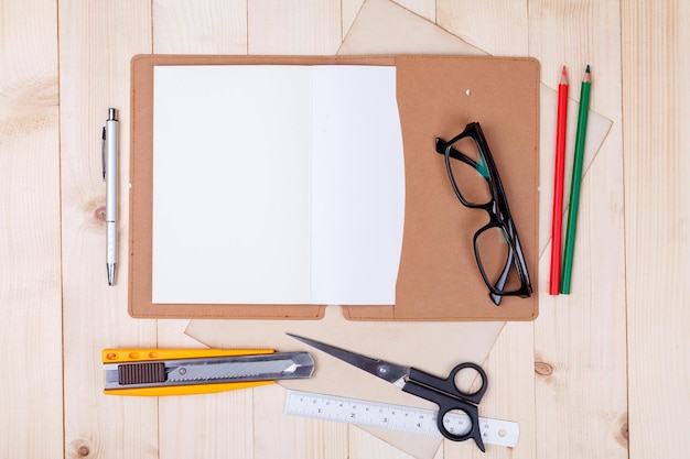 Foto werkplek met kleurpotloden en benodigdheden notebook lenzenvloeistof op houten tafel