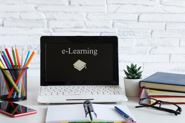 Werkplek met laptop en boeken Elearning online onderwijsconcept