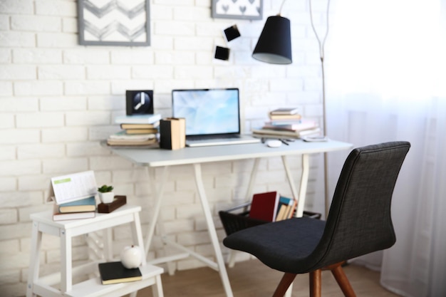 Werkplek met laptop tafellamp en stoel in lichte kamer