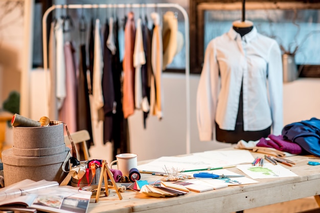 Werkplek voor modeontwerper met op maat gemaakte gereedschappen en tekeningen op tafel