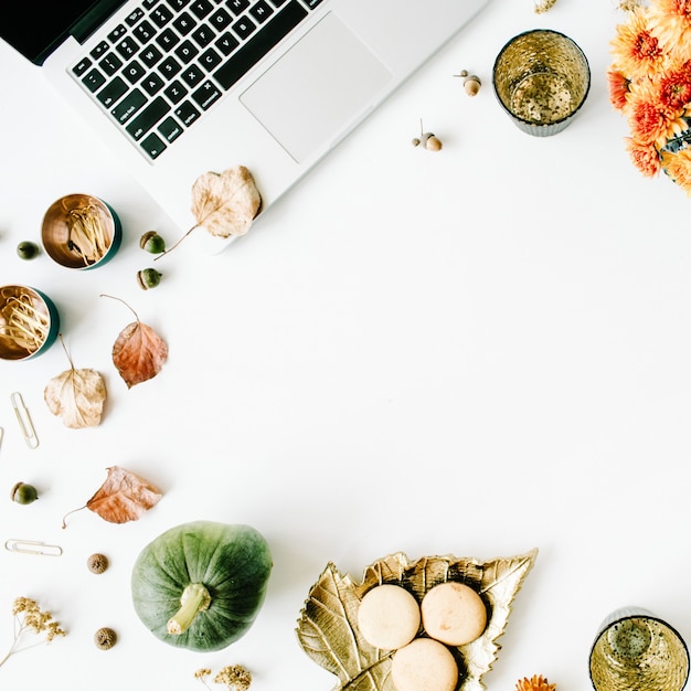 werkruimte met laptop, chrysantenboeket, pompoen, bladeren, schaar op wit