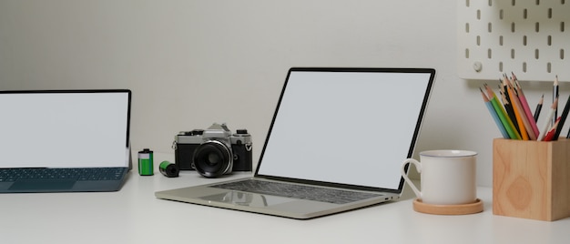 Werktafel met mock-up laptop, tablet, briefpapier, camera en koffiekop