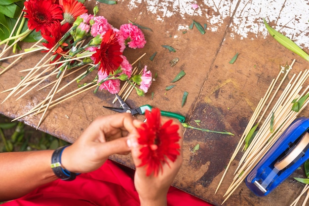 Werktafel van bloemist. Bloemist die op het werk boeket creëren bij bloemwinkel. Bovenaanzicht.