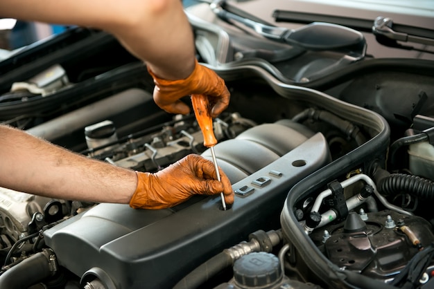 Werktuigkundige die aan een motor van een auto werkt