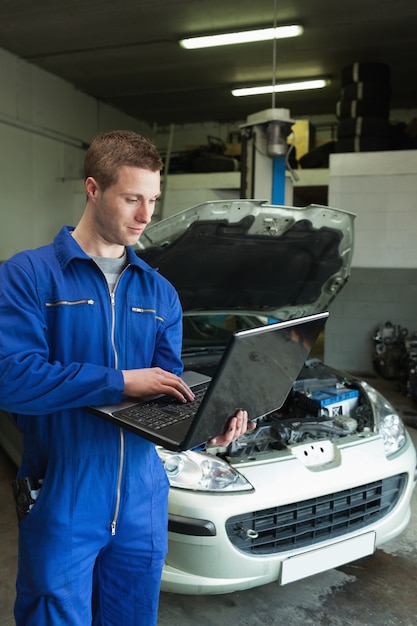 Werktuigkundige die laptop met behulp van