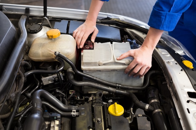 Werktuigkundige die onder kap van auto onderzoeken