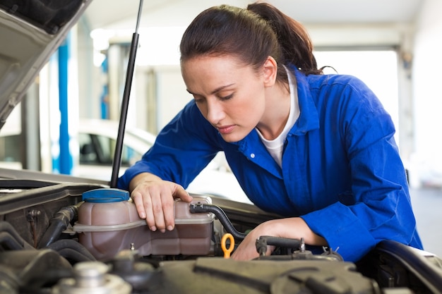 Werktuigkundige die onder kap van auto onderzoeken