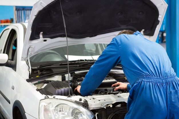 Werktuigkundige die onder kap van auto onderzoeken