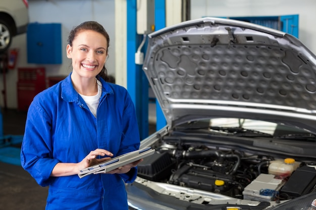 Werktuigkundige die tablet gebruiken om auto te bevestigen