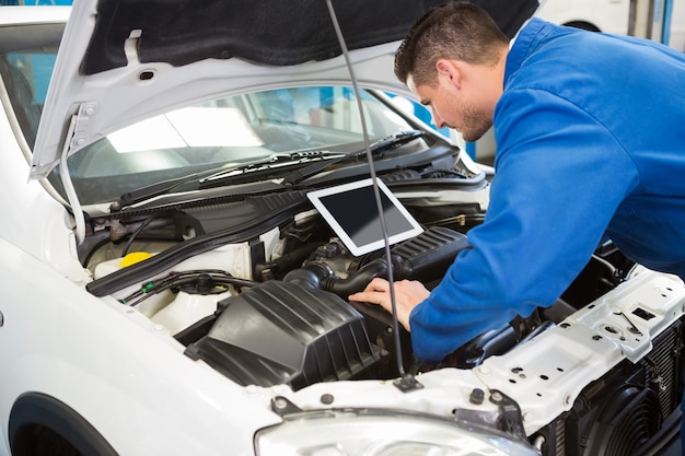 Werktuigkundige die tablet gebruiken om auto te bevestigen