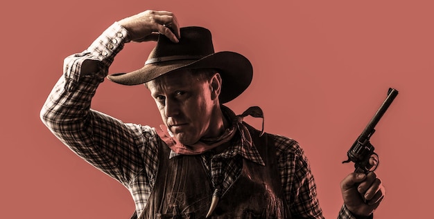 West, geweren. portret van een cowboy. portret van boer of cowboy in hoed. amerikaanse boer. portret van een man met een cowboyhoed, een pistool. portret van een cowboy.