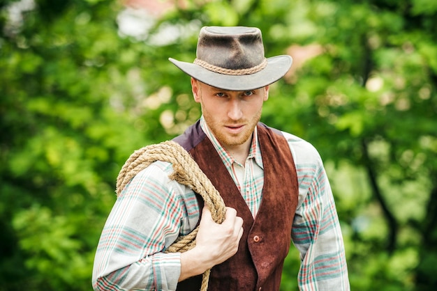 Westerse stijl mannen mode Knappe cowboy in plaid shirt op prachtige landelijke natuur achtergrond Sexy m