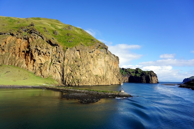 Westman islands, Vestmannaeyjar in summer. Green grass and moss on the top of the nearby mountains cliffs.