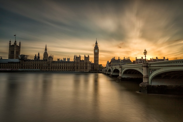 Westminster Abbey and Big Ben over the Thames in London with reflection on river