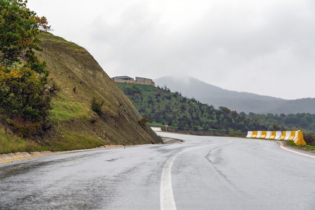 Wet asphalt road in mountainous area