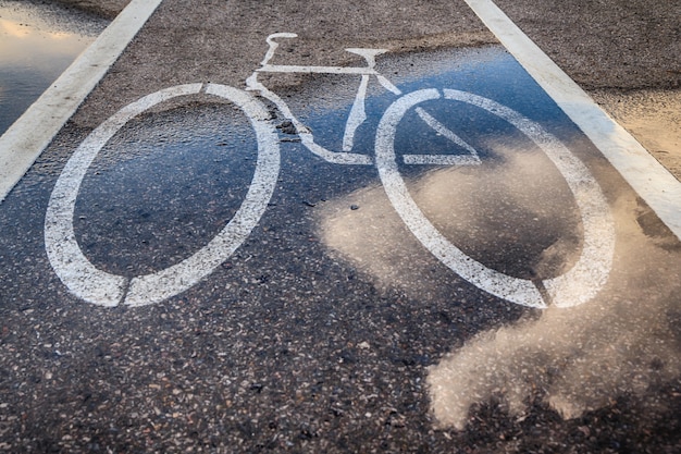 Bicicletta bagnata corsia e riflesso delle nuvole