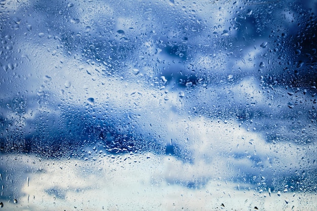 Wet, fogged glass in rain against background of clouds. cloudy rainy clouds.