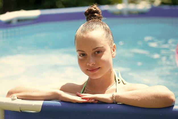 Wet girl child enjoy chill pool day during summer vacation chilling
