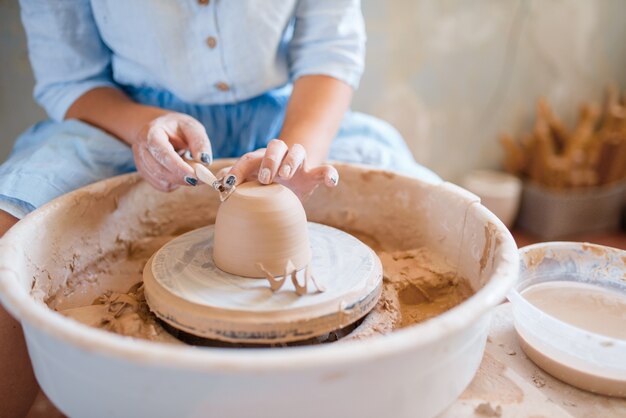 Wet pot on pottery wheel in workshop