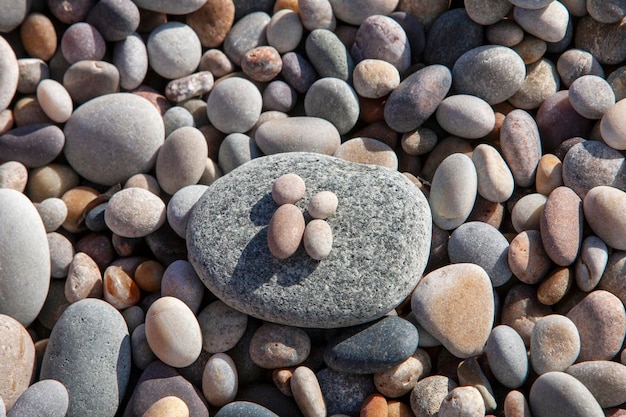Foto pebbles di spiaggia rotolati bagnati pietre a forma di persone texture di sfondo naturale