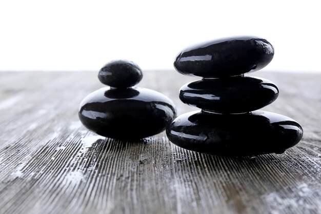 Wet spa stones on wooden table closeup