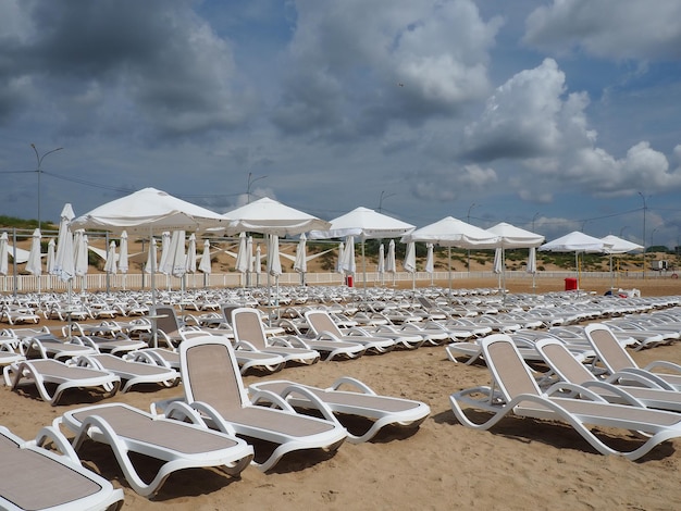 Wet sunbeds and umbrellas on the sea beach during heavy rain storm on the beach