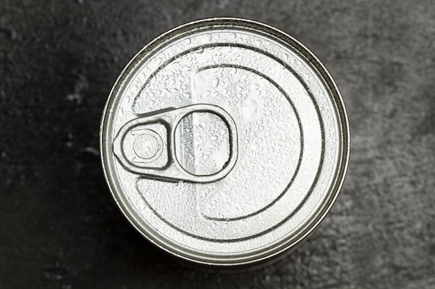 A wet tin can on a dark background