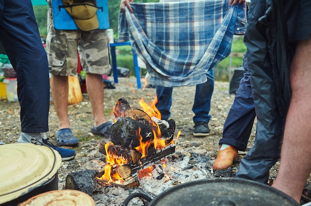 Wet tourists hike around the campfire and dry their clothes