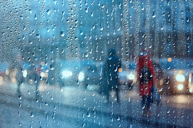 Wet window city lights rain drops, abstract background autumn\
winter glow glass